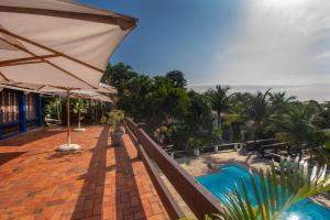 a patio with an umbrella and a swimming pool at Pousada Lestada by Latitud Hoteles in Búzios