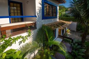 a house with a bench on the side of it at Pousada Lestada by Latitud Hoteles in Búzios