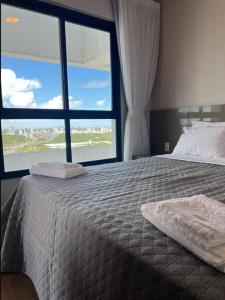 a bedroom with a large bed with a large window at Aparthotel Astron in Salvador