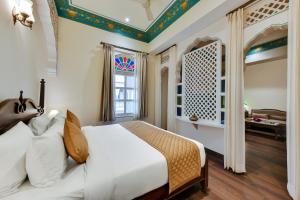 a bedroom with a white bed and a window at WelcomHeritage Ramgarh in Panchkula
