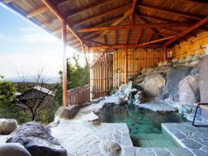 una piscina d'acqua in un edificio con tetto in legno di We Home Villa - Jogasaki Onsen - - Vacation STAY 13634v a Ito