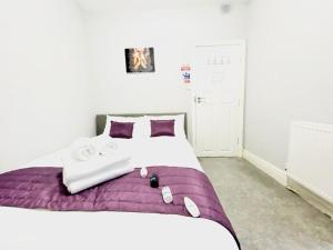 a bedroom with a large bed with purple sheets and towels at Blackpool - Seaside in Blackpool