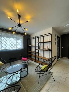 een woonkamer met stoelen en een tafel bij Vidrio Suites Col Americana in Guadalajara