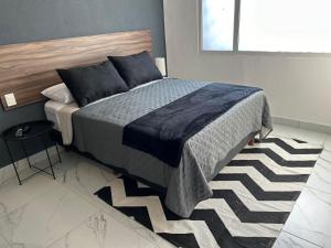 een slaapkamer met een bed in een kamer met een raam bij Vidrio Suites Col Americana in Guadalajara