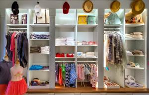 a closet with white shelves filled with clothes at Baron's Cove in Sag Harbor