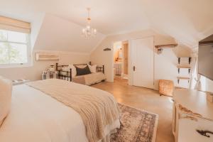 a white bedroom with a bed and a couch at Shades of Provence in Riebeek-Kasteel