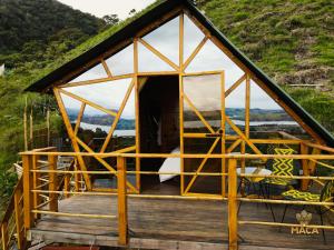 a small house with a large window on a deck at MACA GLAMPING in Calima