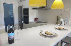 una cocina blanca con una botella de vino y copas en Luxury apartment in Higuerón - Serenity en Málaga