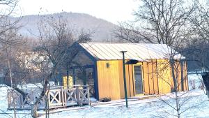 a small yellow building with snow on the ground at Princess Ślęża in Sady