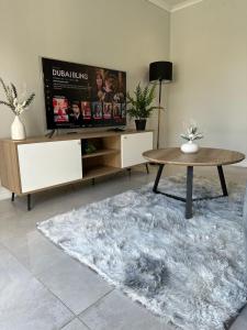 a living room with a table and a rug at Urban Cosy City Haven in Cape Town