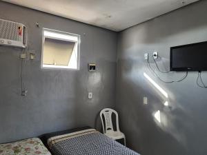 Habitación pequeña con cama y ventana en Condomínio Center luz en Teresina