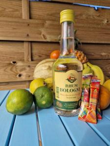 uma garrafa de álcool sentada numa mesa com fruta em appartement T2 avec jacuzzi em Baie-Mahault