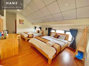 a large bedroom with two beds and a desk at HANZ Hoa Dang Hotel in Da Lat