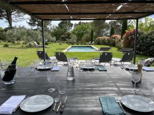 un tavolo con bicchieri e piatti e una bottiglia di vino di Lou Pantai, Bed and breakfast, Double Bedroom ad Aix en Provence