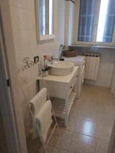 ein weißes Badezimmer mit einem Waschbecken und einem Spiegel in der Unterkunft Casa Coralba in Pavia