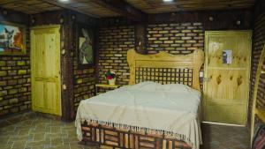 1 dormitorio con 1 cama en una habitación con paredes de ladrillo en HOTEL & SPA LOS AGAVES, en Las Ánimas