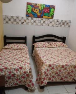 Duas camas sentadas uma ao lado da outra num quarto em Pousada em Fazenda Nova Dona Rosy em Fazenda Nova