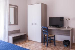 a bedroom with a cabinet and a chair and a television at B&B Fontanelle in Trapani