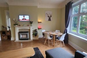 a living room with a table and a fireplace at Spacious Guest Flat near Roundhay Park in Roundhay