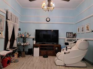 sala de estar con TV, sofá y silla en Rustic Sunflower, en Mount Crosby