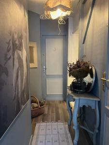 um corredor com uma porta azul e uma mesa com um cesto em Joli studio avec terrasse em Roubaix