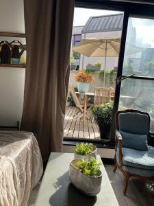 Zimmer mit einem Bett und einem Tisch mit Pflanzen auf einer Terrasse in der Unterkunft Joli studio avec terrasse in Roubaix