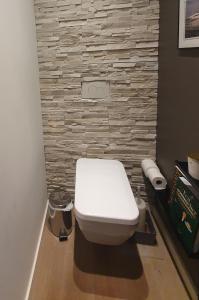 bagno con servizi igienici bianchi e pareti in pietra. di Lou Pantai, Bed and breakfast, Double Bedroom ad Aix en Provence
