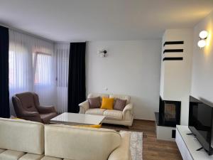 a living room with two couches and a tv at Treva Hotel in Prizren