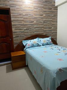 a bedroom with a bed with a wooden headboard at HOSTAL LOS NOGALES in Aguaytía