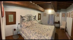 a bedroom with a bed and a table and a chair at Osteria Del Borgo B&B in Montepulciano