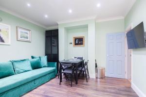 a living room with a green couch and a table at Stylish 2 Bedroom Flat, Sleep 6 & Garden London Zone 2 cls Central in London
