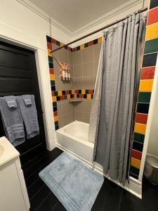 La salle de bains est pourvue d'une douche et d'une baignoire. dans l'établissement Beautiful Bungalow on Main, à Madison