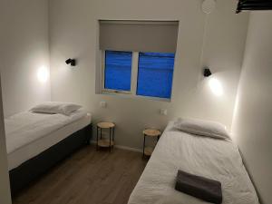 twee bedden in een kamer met twee ramen bij Skógar Lodge in Hvolsvöllur