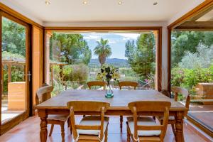 comedor con mesa y sillas y ventana grande en Villa in San Rafael Sleeps 12, en Ses Paisses