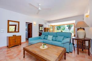 a living room with a blue couch and a table at Villa in San Rafael Sleeps 12 in Ses Paisses +44 photos