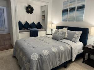 - une chambre avec un lit bleu et blanc et une fenêtre dans l'établissement Beautiful Bungalow on Main, à Madison