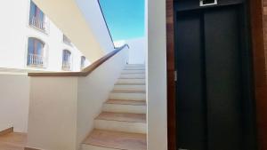 a hallway with stairs and a black door at MyHome Urban Apartments-Air Conditioning-City Center in Puerto del Rosario