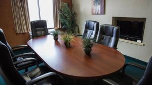 een conferentieruimte met een houten tafel en stoelen bij BridgePointe Hotel & Marina in New Bern