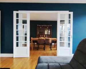Appartement spacieux في Charmes: غرفة طعام مع طاولة والجدار الأزرق