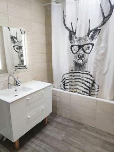 a bathroom with a deer wearing glasses in a shower curtain at Appartement spacieux in Charmes