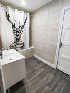a bathroom with a deer shower curtain and a sink at Appartement spacieux in Charmes