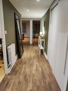 a hallway of a home with a hard wood floor at Appartement spacieux in Charmes