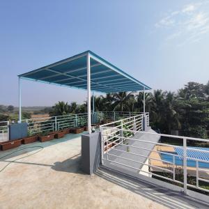 een bushalte met een blauwe baldakijn en banken bij Kasturi Villa - A home away from home in Mandve