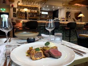 a plate of food on a table with wine glasses at The Bankers Quarters - Apt 2 in Chapel en le Frith