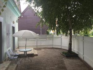 een tafel en stoelen met een parasol naast een hek bij Apartments Abc Ljubljana in Ljubljana