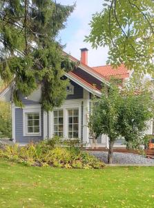 a house with a tree in front of it at Villa Onnela Ämttöö in Pori