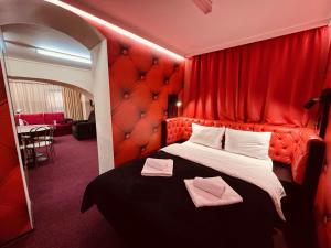 Cette chambre rouge comprend un lit avec un mur rouge. dans l'établissement Excluzive, à Odorheiu Secuiesc