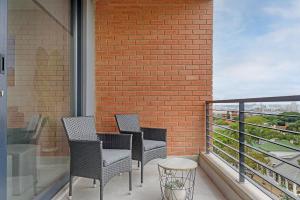 3 sedie e un tavolo sul balcone di 601 at 2SIX2 Florida Road by HostAgents a Durban