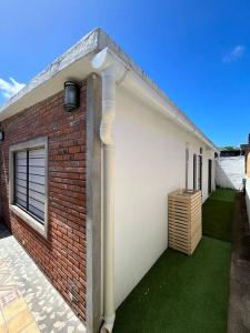 a red brick building with a green yard with a drain at Casa moderna recien terminada in Maldonado