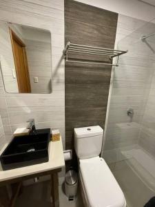 a bathroom with a sink and a toilet and a mirror at Casa moderna recien terminada in Maldonado +14 photos